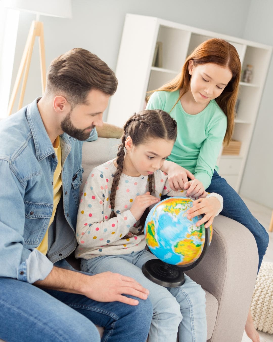 Portrait of three persons sit on sofa look hands hold globe finger pointing Portrait of three persons sit on sofa look hands hold globe finger pointing